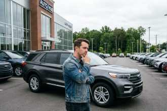 Homme contemplant un SUV dans un concessionnaire moderne