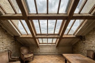Verrière en bois ancienne dans un salon de maison de ville du XIXe siècle avec parquet en point de Hongrie et murs en pierre apparente
